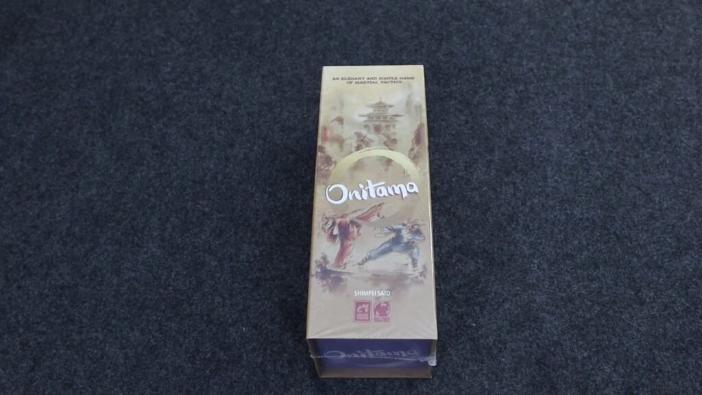 Onitama game box on a dark surface.