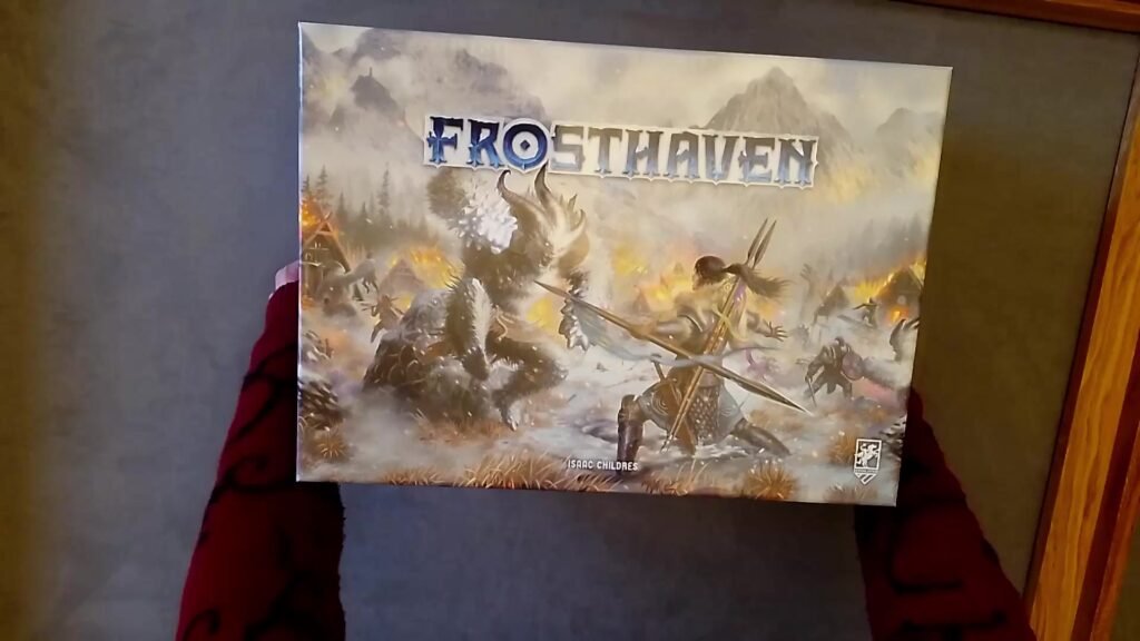 A photograph of the Frosthaven board game box, featuring a dramatic illustration of adventurers battling in a snowy, mountainous landscape.